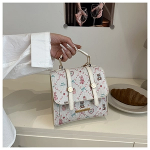 Detail of floral printed handbag with cute bear patterns and gold hardware details
