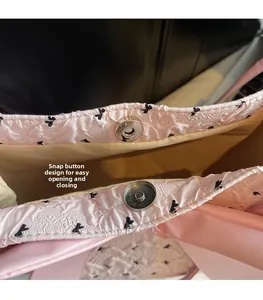Close-up of pink seersucker shoulder bag showing secure magnetic snap button closure