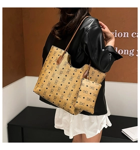 Detail shot of brown monogram tote bag with matching pouch on model's shoulder
