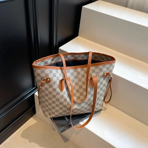 Retro plaid tote bag with brown leather handles and side drawstring on a tiered display