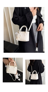 Detailed view of mini white bucket bag with pearl bow charm and lychee leather texture