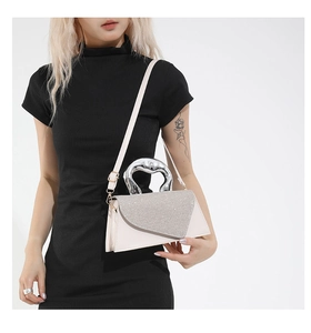 Detail of crossbody bag featuring a sparkling sequined flap and silver heart handle