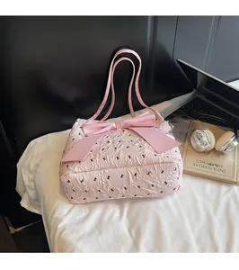 Detailed view of pink tote bag with black bow embroidery and large satin bow decoration