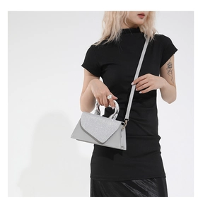 Close-up of sparkling silver sequin handbag with chrome circular handle and leather strap