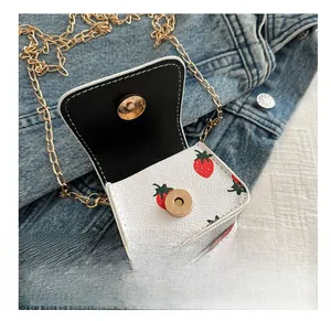 Close-up of strawberry print mini wallet with gold magnetic buckle on denim background