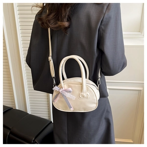 Detailed back view of a cream PU leather pillow bag featuring a chic plaid ribbon charm
