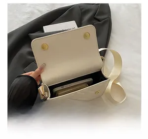 Interior view of white quilted bag showing storage capacity for phone and wallet