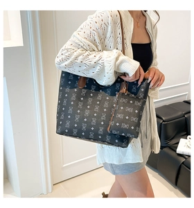Détail du sac cabas à motif d'ours et lanières en cuir marron porté par un modèle