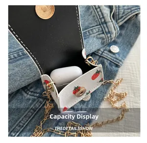 Close-up of strawberry print mini bag showing interior capacity with earphone case