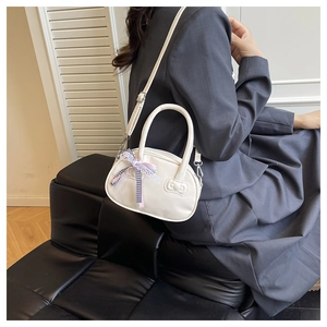 Detailed view of a white bow-embossed bowling bag with purple plaid lace accessory