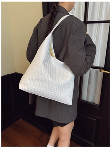 Detail of white woven tote bag with herringbone texture and large capacity for commuting
