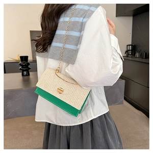 Dettaglio della trama tessuta beige e patta in pelle verde con catena dorata