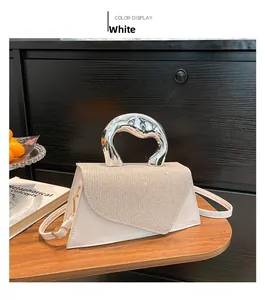 Detail of white leather handbag with glittery flap and oversized silver metal handle