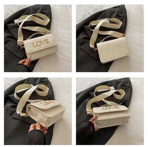 Détails du sac matelassé blanc avec lettrage LOVE doré et large bandoulière en tissu