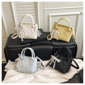 Four mini bucket bags in cream, yellow, blue, and black with pearl lace charms