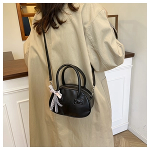 Fashionable black leather bowling bag with bow ribbon shown in a lifestyle setting
