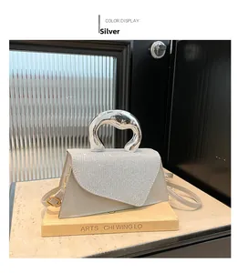 Detail of silver sequined handbag with liquid metal irregular handle on art book