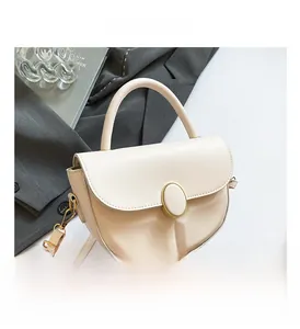 Close-up of cream saddle bag with smooth leather texture and gold hardware details