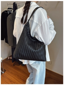 Detail of black woven leather shoulder bag with fine Intrecciato craftsmanship
