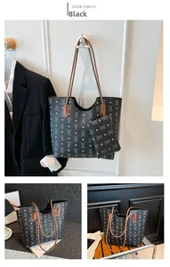 Detail view of black tote bag set featuring bear pattern and brown leather accents