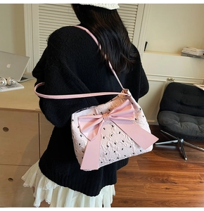 Detail of pink silk bow decoration on shoulder bag with embossed rabbit pattern