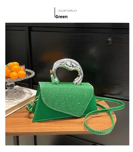 Detail view of green mini square bag with glitter flap and metallic handle on wooden table