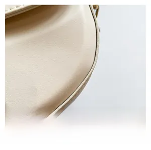 Close-up of cream white leather bag showing lychee texture and neat stitching details