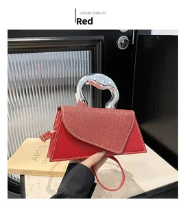 Detail of red trapezoid handbag with silver liquid metal handle and sequined flap