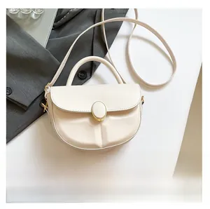 Detail of cream semi-circular leather handbag with gold oval clasp and top handle