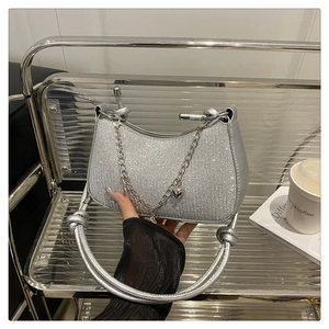 Détail du sac demi-lune à paillettes argentées avec chaîne et pendentif coeur