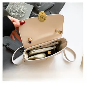 Internal view of cream saddle bag showing storage space for phone and cosmetics