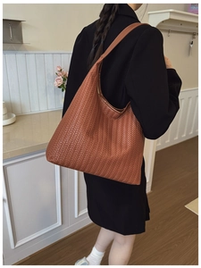 Close-up of the large woven brown tote bag featuring detailed intrecciato craftsmanship