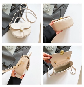 Detail view of cream white saddle bag with golden buckle and interior compartment