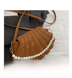 Detail of brown shell-shaped bag with faux snakeskin texture and pearl handle