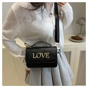 Détail du sac à bandoulière en cuir matelassé noir avec lettrage métallique doré LOVE