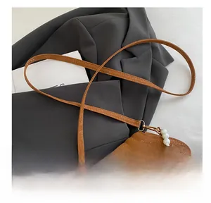 Detail of brown shell bag with pearl handle and snakeskin texture leather surface