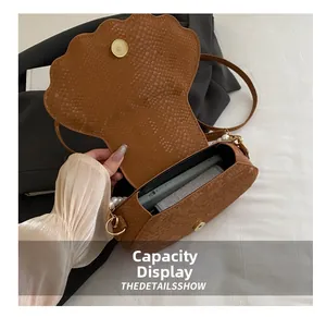Detail of brown shell bag showing interior capacity for phone and small wallet