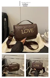 Détail du matelassage en losange et du logo LOVE doré sur le sac en cuir marron foncé