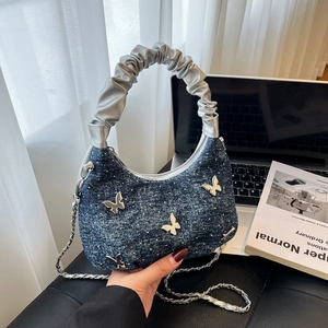 Blue denim crossbody bag with butterfly charms and silver metallic chain strap