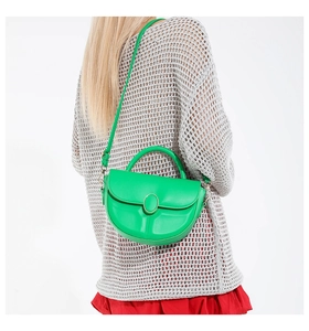 Detail of green saddle bag showing gold buckle and textured embossed bottom design