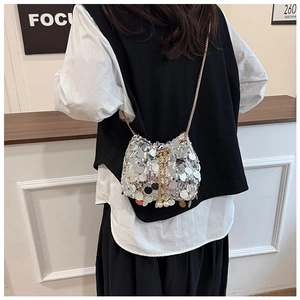 Detail of silver sequin bucket bag with pearl drawstring and golden chain strap