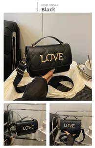 Détail d'un sac cylindrique matelassé avec lettrage LOVE doré et bandoulière chaîne