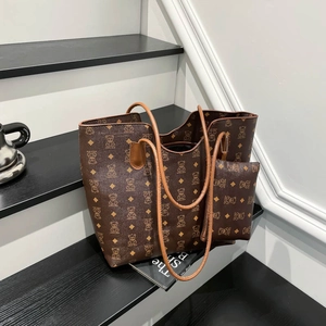 Deep brown tote bag set with bear monogram print and light brown handles on stairs