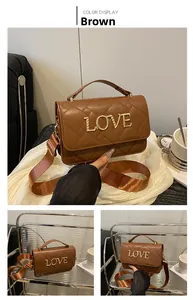 Détail du sac matelassé marron avec lettre LOVE en métal doré et large bandoulière