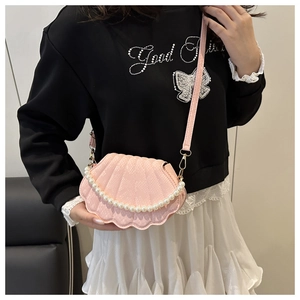 Detailed view of a pink shell-shaped crossbody bag with elegant pearl chain decoration