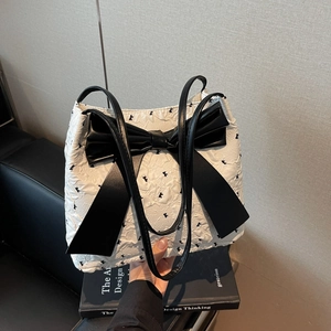 Chic quilted white tote bag with large black leather bow and rabbit print detail