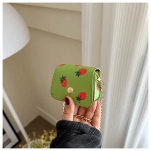 Close-up of green lychee leather mini wallet with strawberry print and gold chain strap