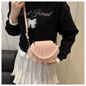 Vue détaillée du sac rose en forme de coquillage avec chaîne de perles sur le modèle