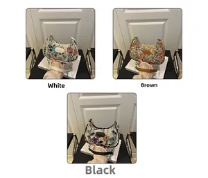 Détail de broderies florales sur sacs demi-lune avec bandoulières en chaîne