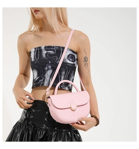 Close-up of pink crescent handbag featuring gold oval buckle and adjustable strap